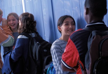A group of students hanging out in a middle school hallway